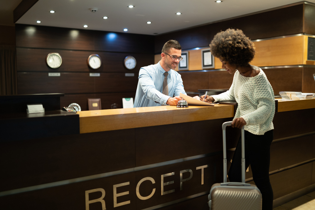 A receptionist welcomes a client to a luxury hotel
